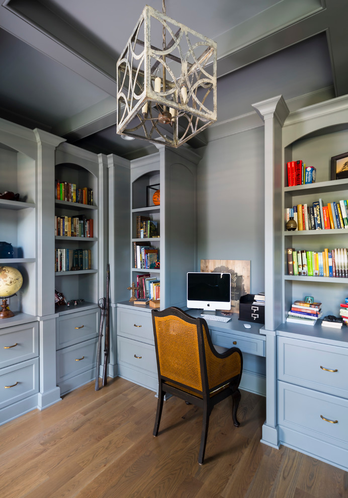 Diseño de despacho clásico de tamaño medio sin chimenea con paredes grises, suelo de madera en tonos medios y escritorio empotrado