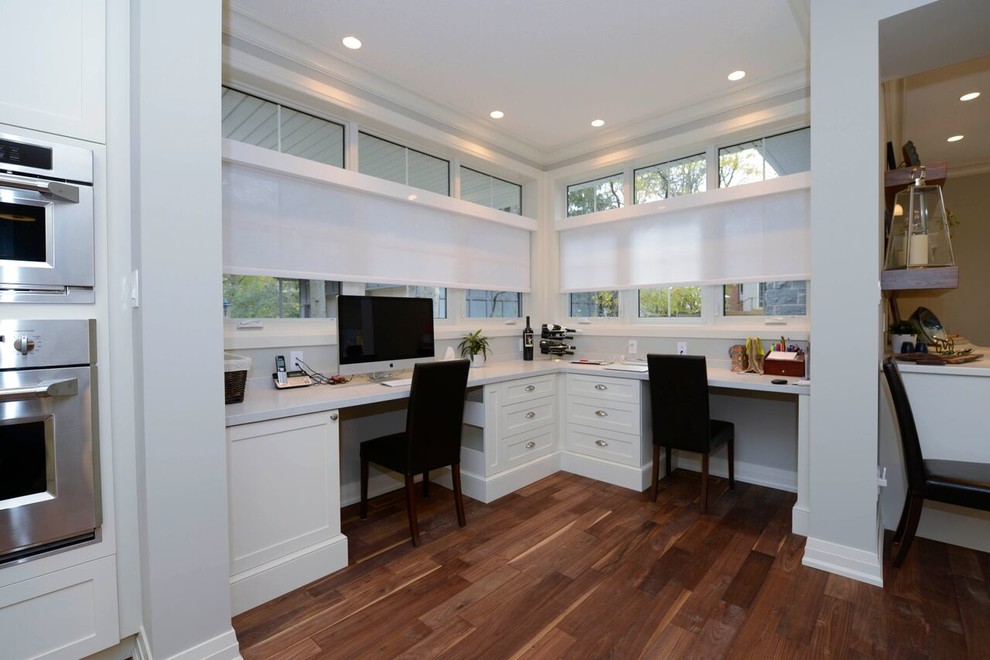 Cette photo montre un bureau moderne avec un mur gris, un sol en bois brun, un bureau intégré et un sol marron.