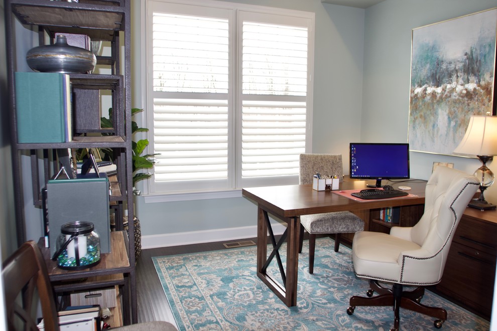 Aménagement d'un petit bureau classique avec un mur bleu, parquet foncé, aucune cheminée, un bureau indépendant et un sol marron.