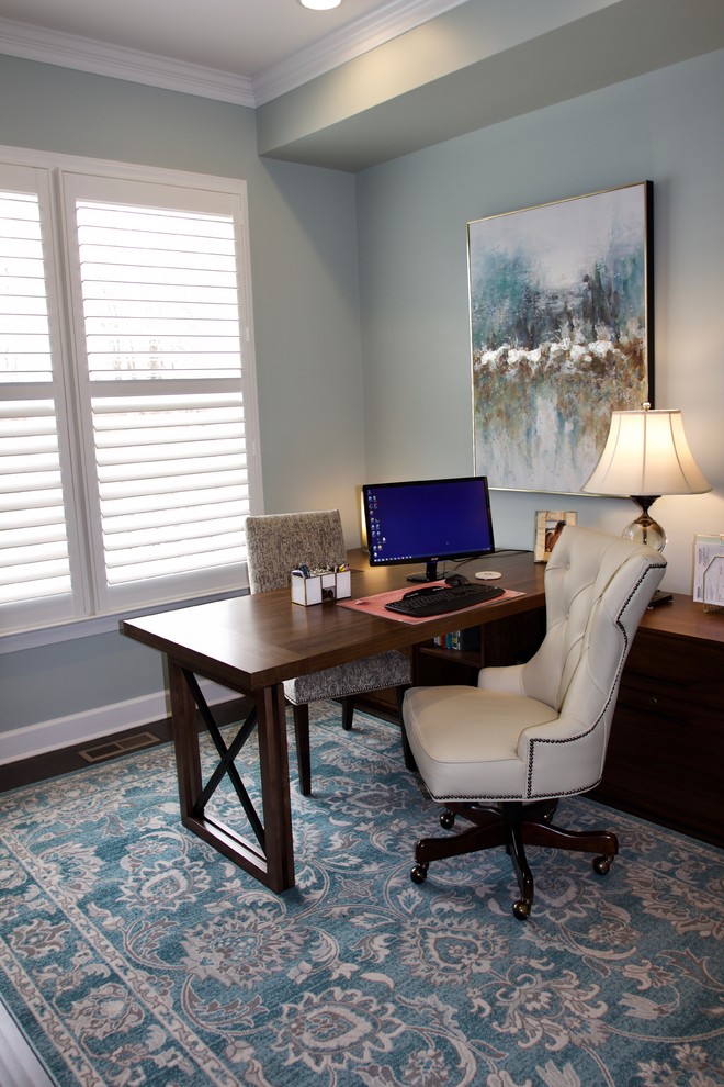 Diseño de despacho clásico renovado pequeño sin chimenea con paredes azules, suelo de madera oscura, escritorio independiente y suelo marrón