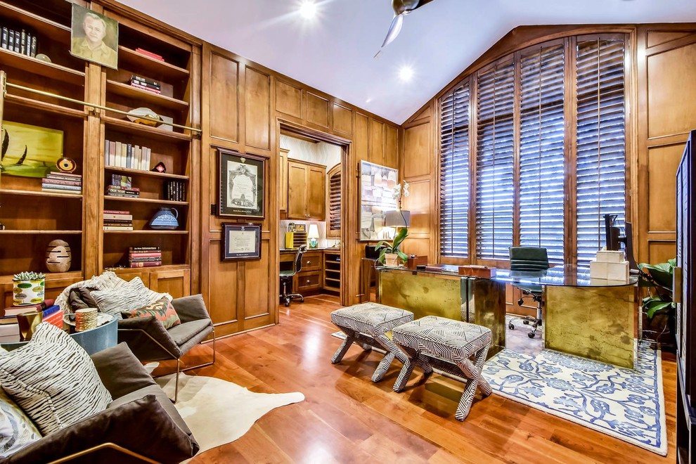 Klassisches Arbeitszimmer ohne Kamin mit Arbeitsplatz, braunem Holzboden, freistehendem Schreibtisch und orangem Boden in Austin