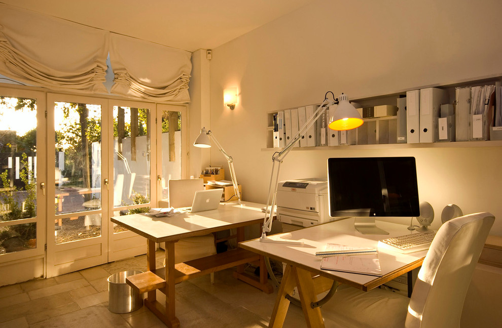 Ejemplo de despacho contemporáneo con paredes blancas y escritorio independiente