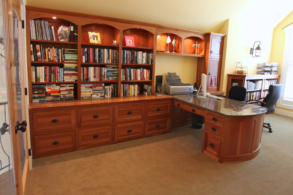 Inspiration för ett funkis hemmabibliotek, med ett inbyggt skrivbord, gula väggar och heltäckningsmatta