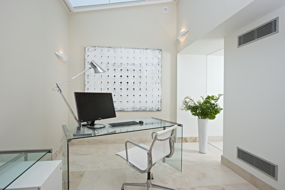 Diseño de despacho contemporáneo pequeño sin chimenea con suelo de mármol, escritorio independiente y paredes beige