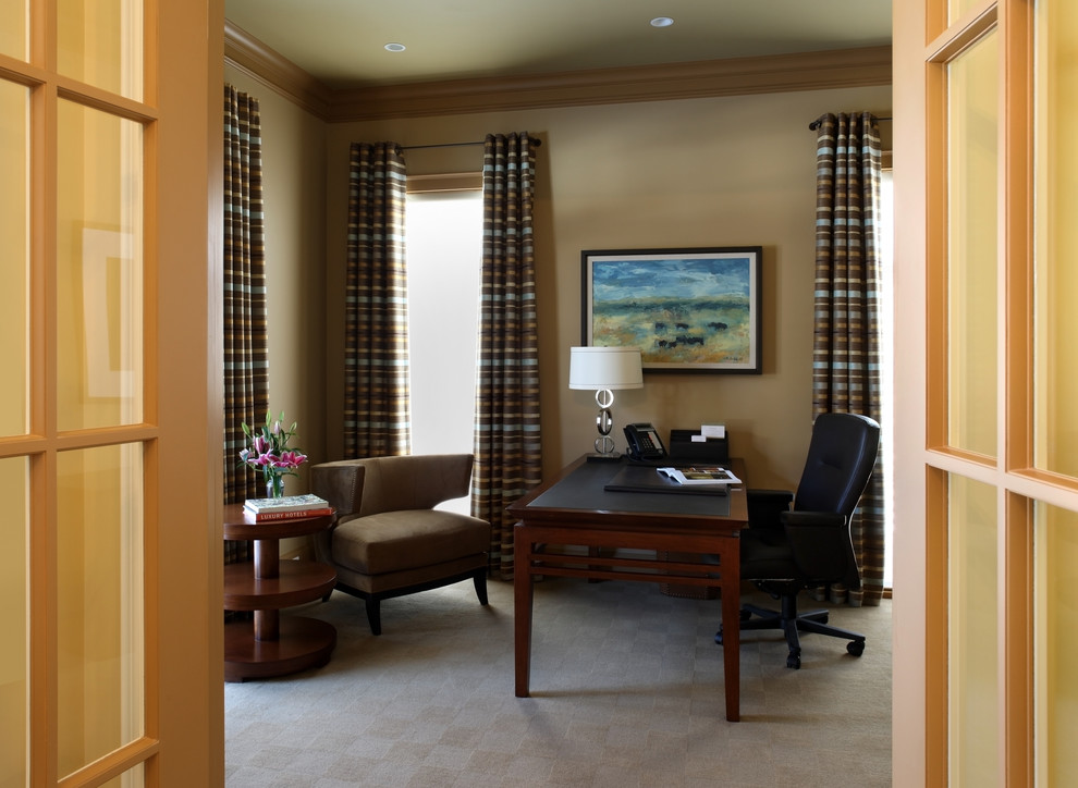 Modelo de despacho clásico con paredes beige, moqueta y escritorio independiente