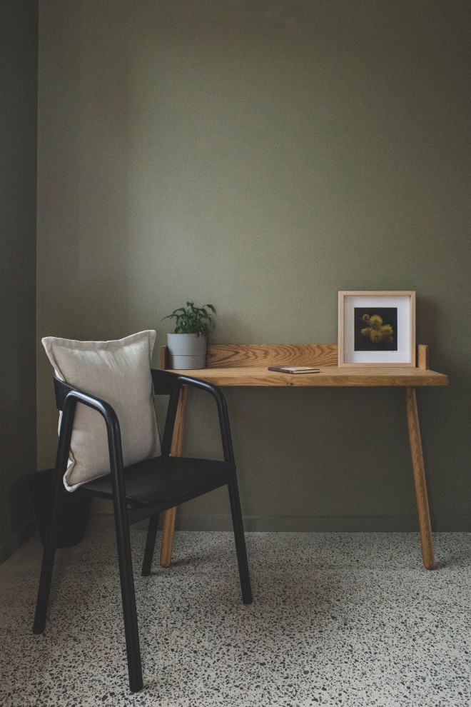 Immagine di un piccolo ufficio minimal con pareti verdi, pavimento in cemento, scrivania incassata e pavimento grigio