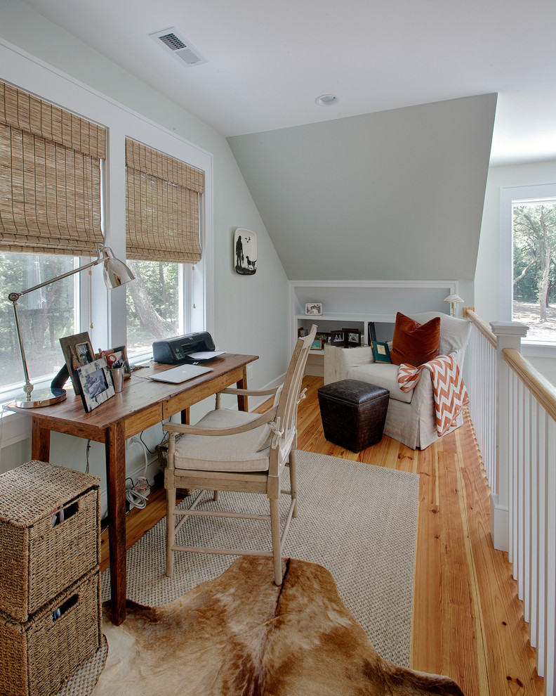 Immagine di uno studio tropicale con pareti grigie, pavimento in legno massello medio e scrivania autoportante
