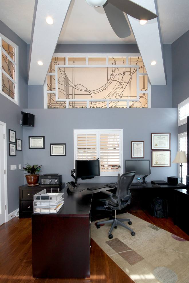 Cette photo montre un bureau tendance de taille moyenne avec un mur bleu, un bureau indépendant et parquet foncé.