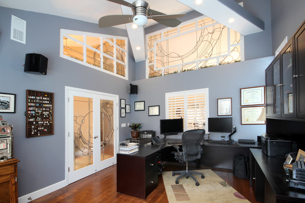 Ispirazione per un ufficio minimalista di medie dimensioni con pareti blu, pavimento in legno massello medio e scrivania autoportante