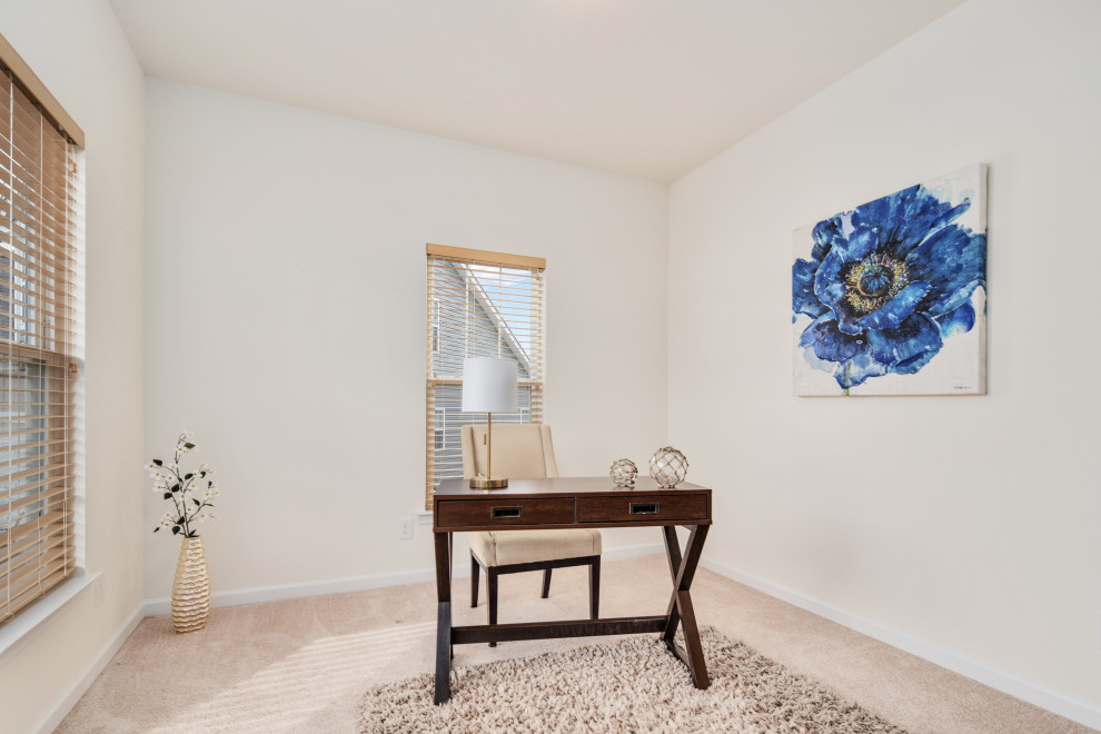 Imagen de despacho clásico de tamaño medio con paredes beige, moqueta, escritorio independiente y suelo beige