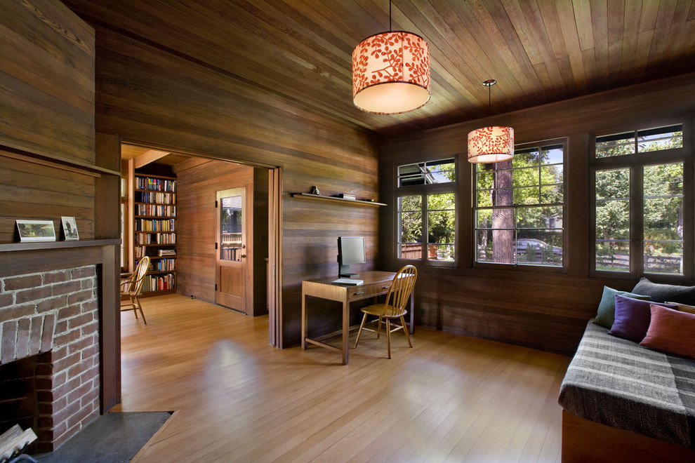 Foto di uno studio minimal con pavimento in legno massello medio e scrivania autoportante