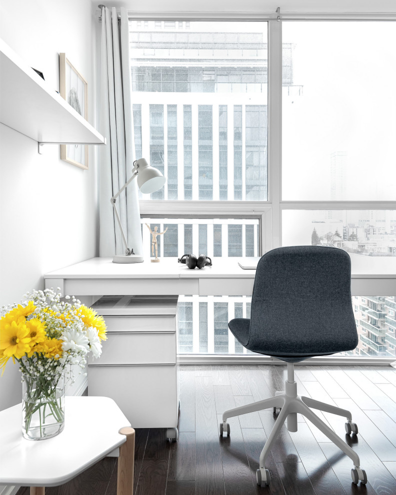 Mittelgroßes Modernes Arbeitszimmer mit Arbeitsplatz, weißer Wandfarbe, dunklem Holzboden, freistehendem Schreibtisch und braunem Boden in Toronto