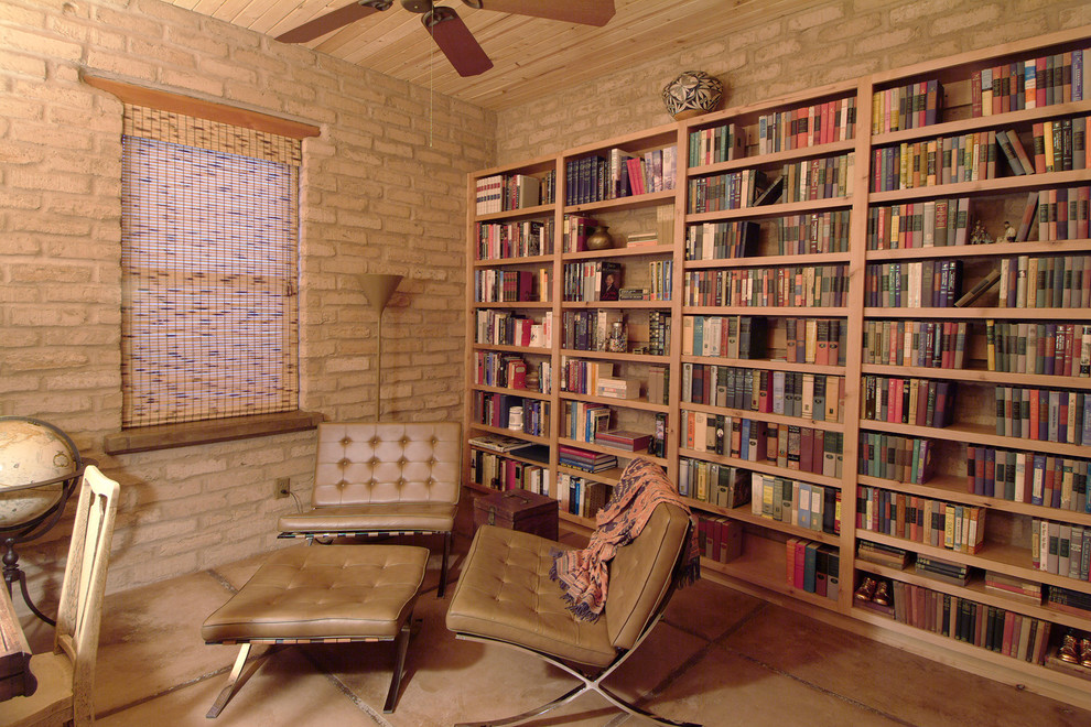 Aménagement d'un bureau montagne de taille moyenne avec une bibliothèque ou un coin lecture, un mur beige, sol en béton ciré et un sol beige.