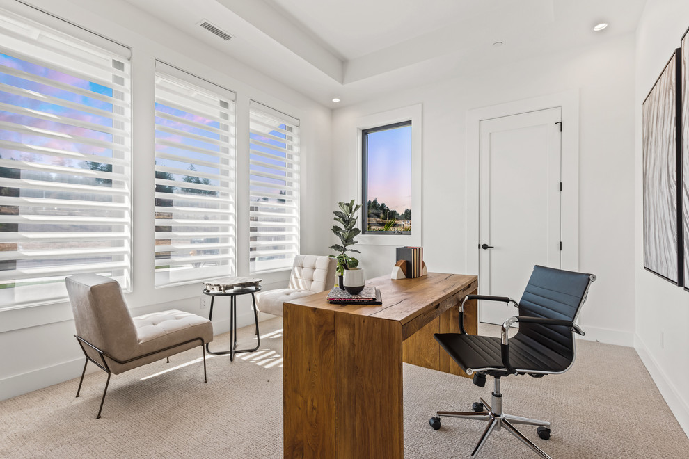 Modelo de despacho actual con paredes blancas, moqueta, escritorio independiente y suelo beige