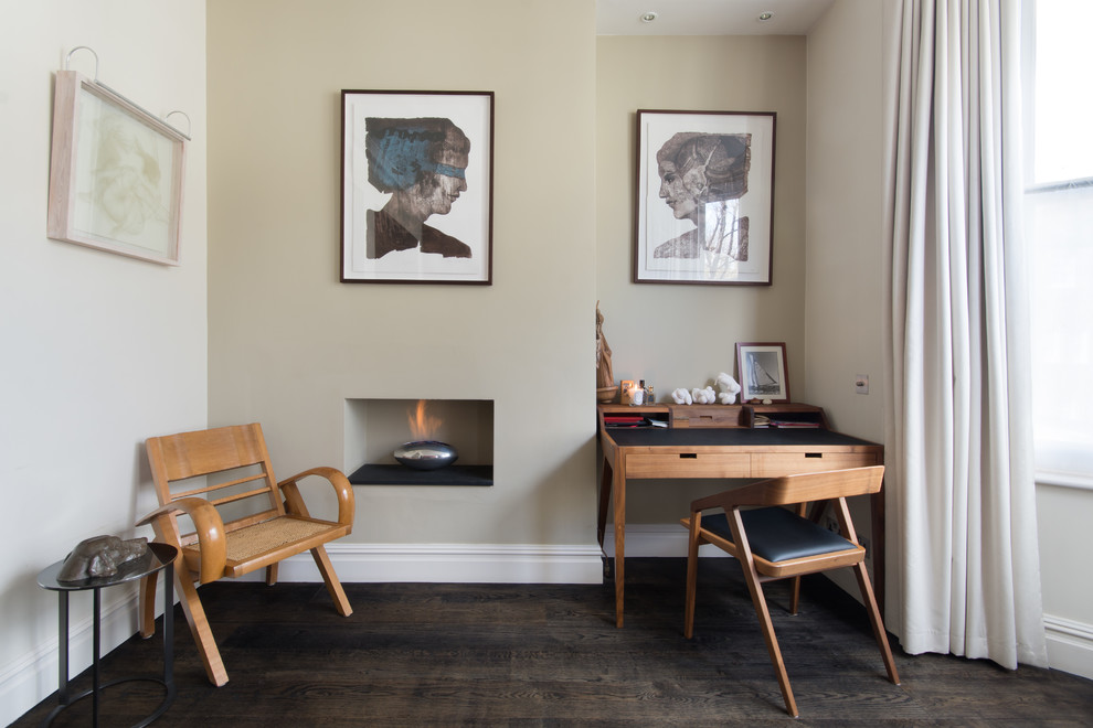 ロンドンにあるコンテンポラリースタイルのおしゃれなホームオフィス・書斎 (マルチカラーの壁、濃色無垢フローリング、横長型暖炉、自立型机、茶色い床) の写真