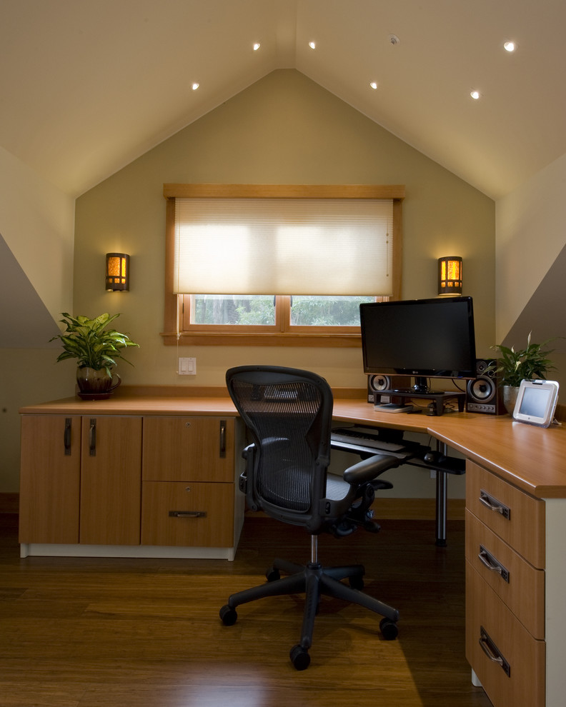 Diseño de despacho tradicional con paredes blancas, suelo de madera en tonos medios, escritorio independiente y suelo marrón