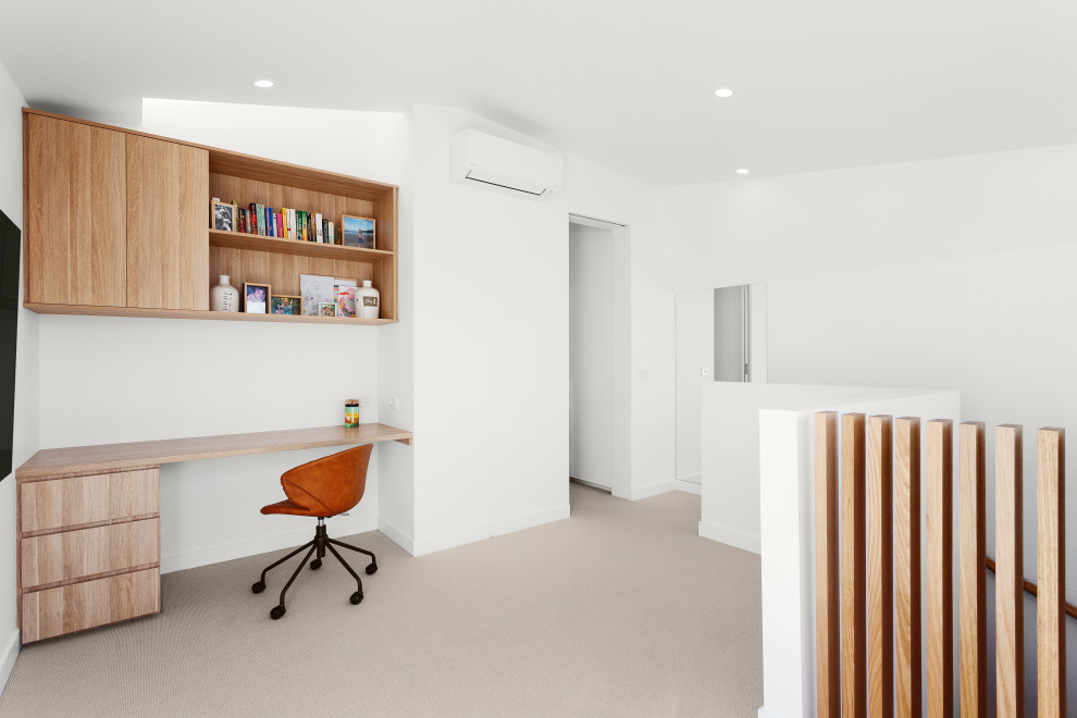 Idéer för att renovera ett litet funkis hemmabibliotek, med vita väggar, heltäckningsmatta, ett inbyggt skrivbord och beiget golv