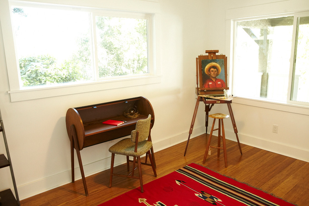 Eklektisk inredning av ett arbetsrum, med vita väggar, mellanmörkt trägolv och ett fristående skrivbord