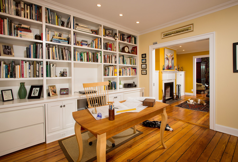 Idee per un ufficio chic di medie dimensioni con pareti gialle, pavimento in legno massello medio, nessun camino, scrivania autoportante e pavimento marrone