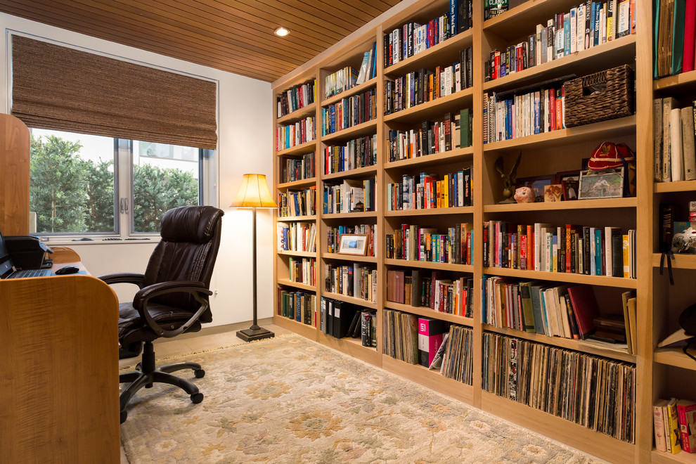 Cette photo montre un bureau moderne de taille moyenne avec une bibliothèque ou un coin lecture, un mur blanc, un sol en travertin, aucune cheminée, un bureau indépendant et un sol blanc.