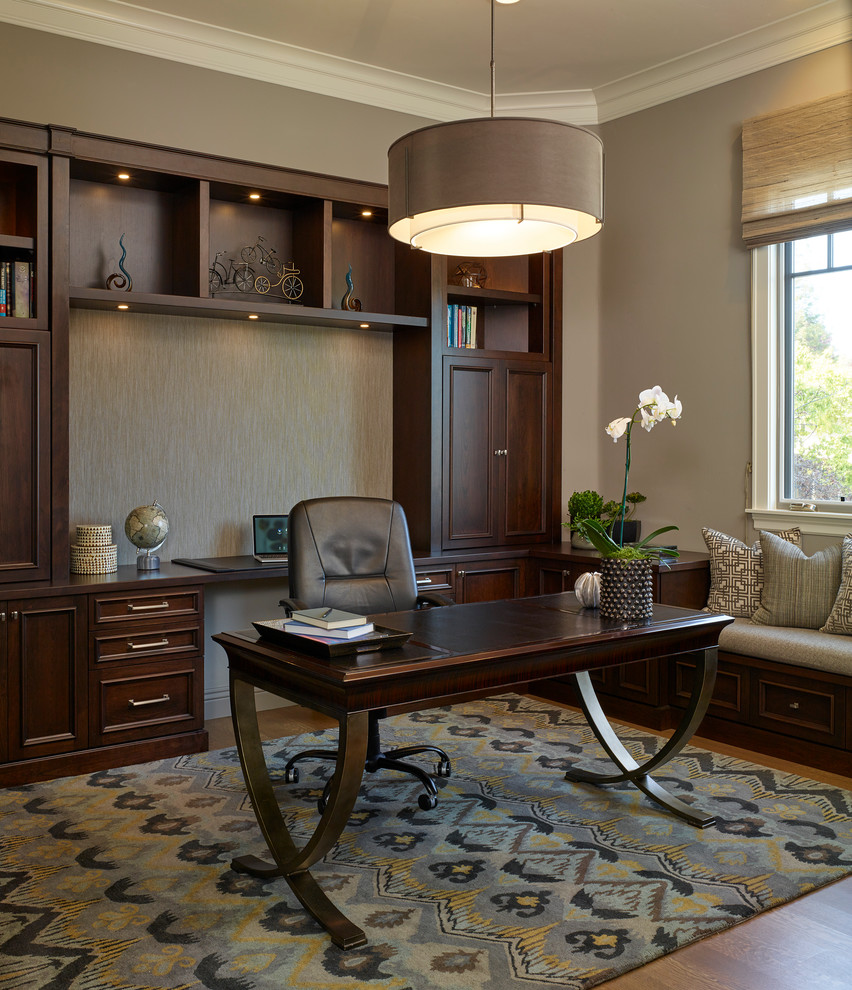 This is an example of a medium sized classic study in San Francisco with grey walls, medium hardwood flooring and a freestanding desk.