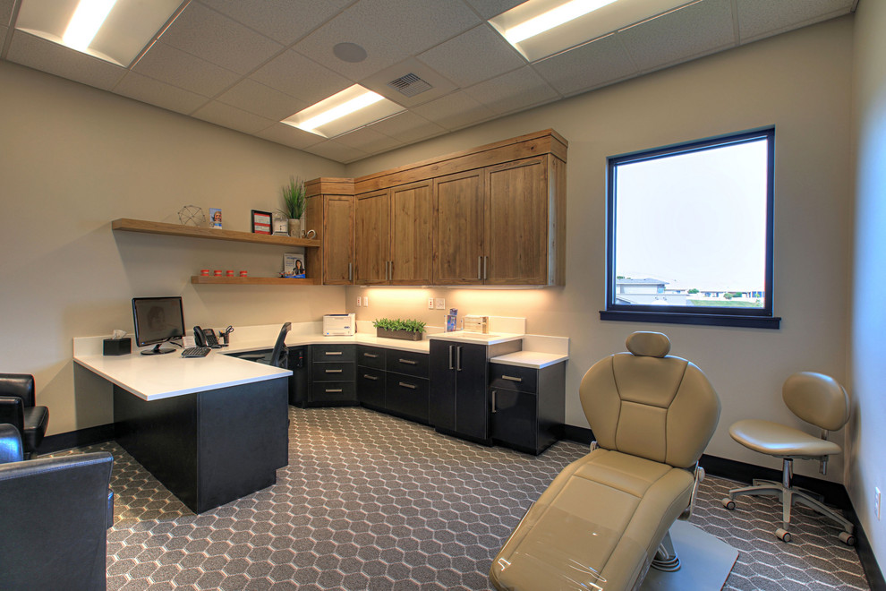 Cette image montre un bureau minimaliste avec un mur blanc, sol en stratifié, un bureau intégré et un sol gris.