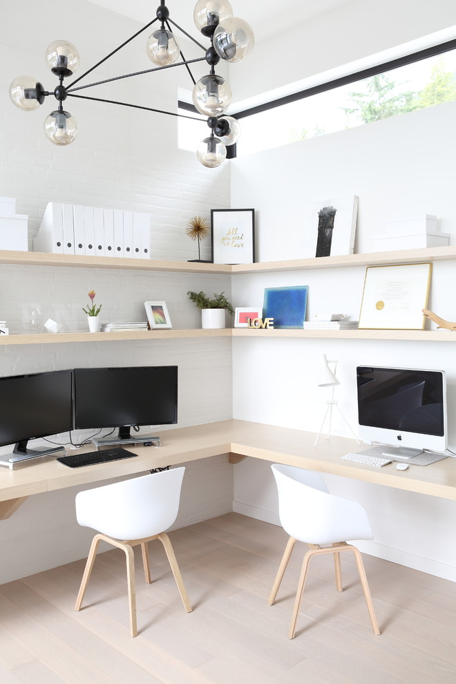 Foto de despacho actual de tamaño medio sin chimenea con paredes blancas, suelo de madera clara, escritorio empotrado y suelo beige