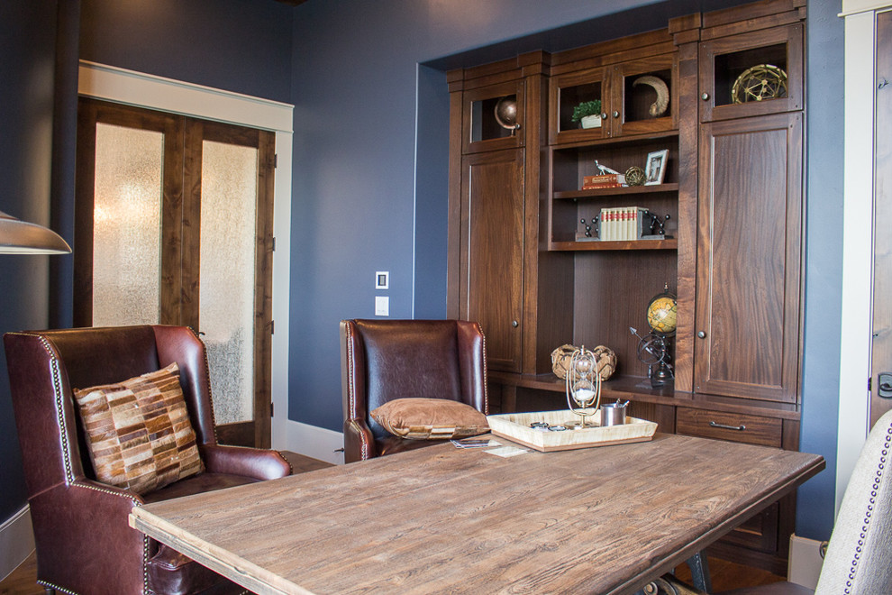 Foto de despacho de estilo americano de tamaño medio sin chimenea con paredes azules, suelo de madera oscura y escritorio independiente