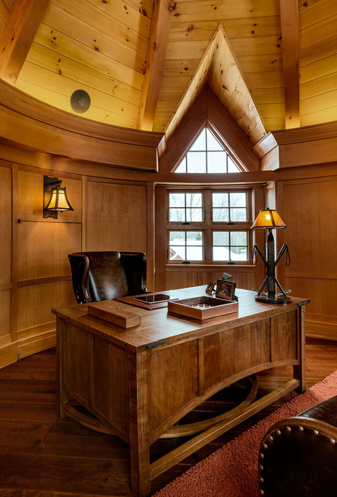 Imagen de despacho actual grande con paredes marrones, suelo de madera oscura y escritorio independiente