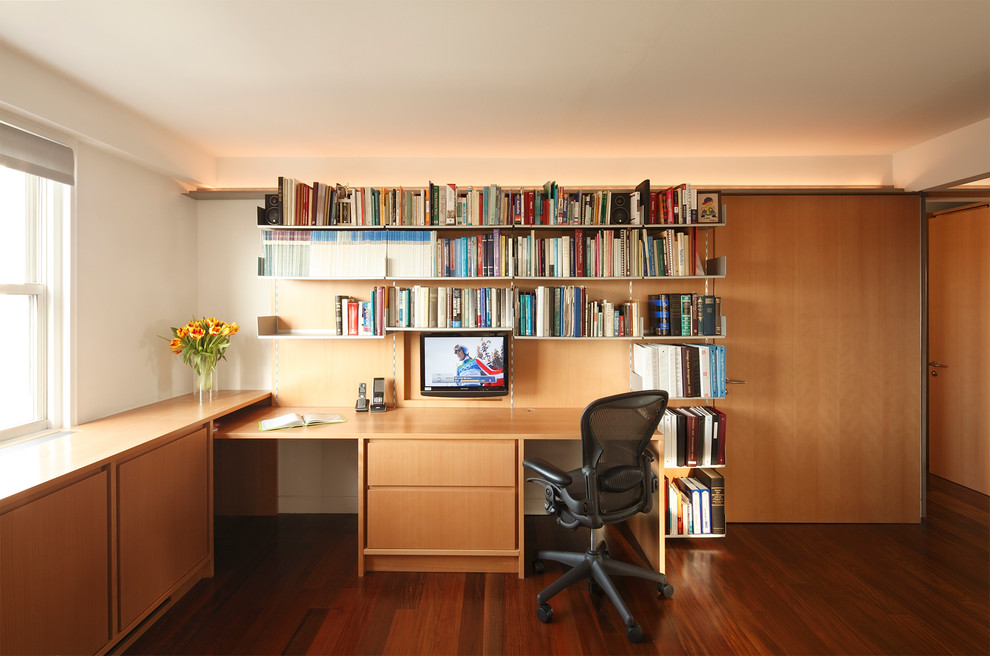 Idee per un ufficio design con pareti bianche, parquet scuro e scrivania incassata