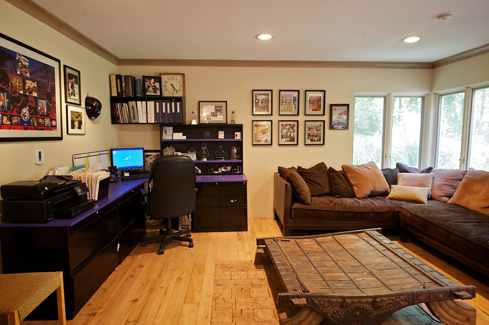 Aménagement d'un grand bureau moderne avec un mur beige, parquet clair, une cheminée d'angle, un manteau de cheminée en plâtre et un bureau indépendant.