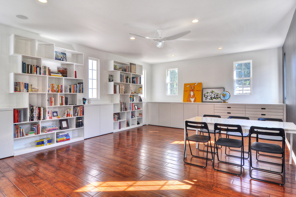 Foto di un ampio studio design con pareti bianche, pavimento in legno massello medio, nessun camino e scrivania autoportante
