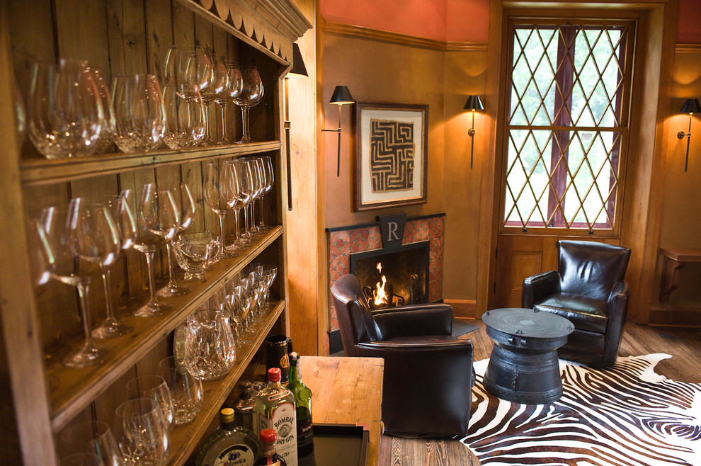 Imagen de despacho tradicional con suelo de madera en tonos medios, chimenea de esquina y marco de chimenea de baldosas y/o azulejos