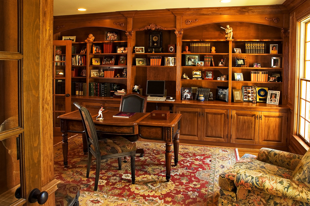 Esempio di un ampio studio chic con pavimento in legno massello medio, scrivania autoportante, libreria e pareti marroni