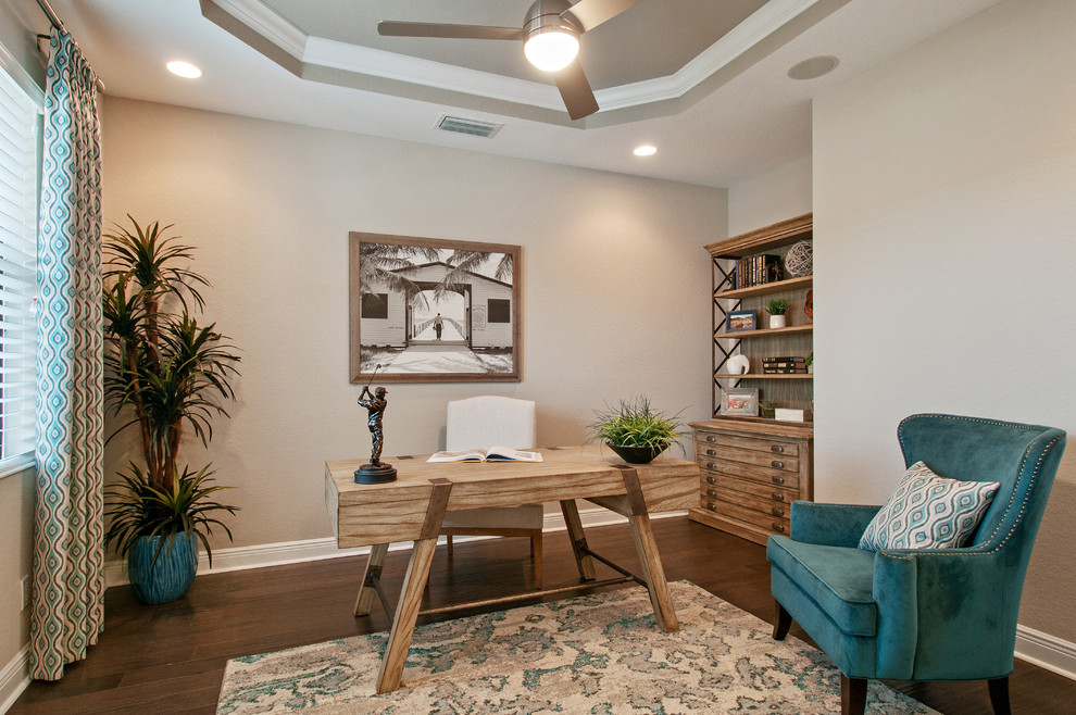 Diseño de despacho tradicional renovado con paredes beige, suelo de madera oscura y escritorio independiente