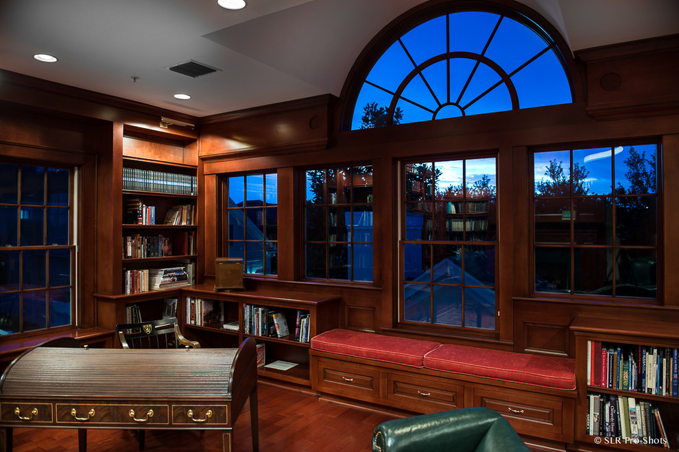Idéer för att renovera ett vintage hemmabibliotek, med bruna väggar, mellanmörkt trägolv och ett fristående skrivbord