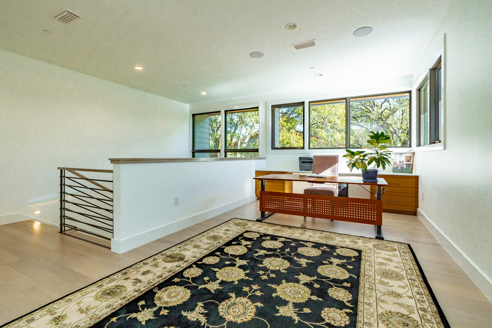 Foto di un grande ufficio contemporaneo con pareti bianche, parquet chiaro, scrivania autoportante e pavimento marrone