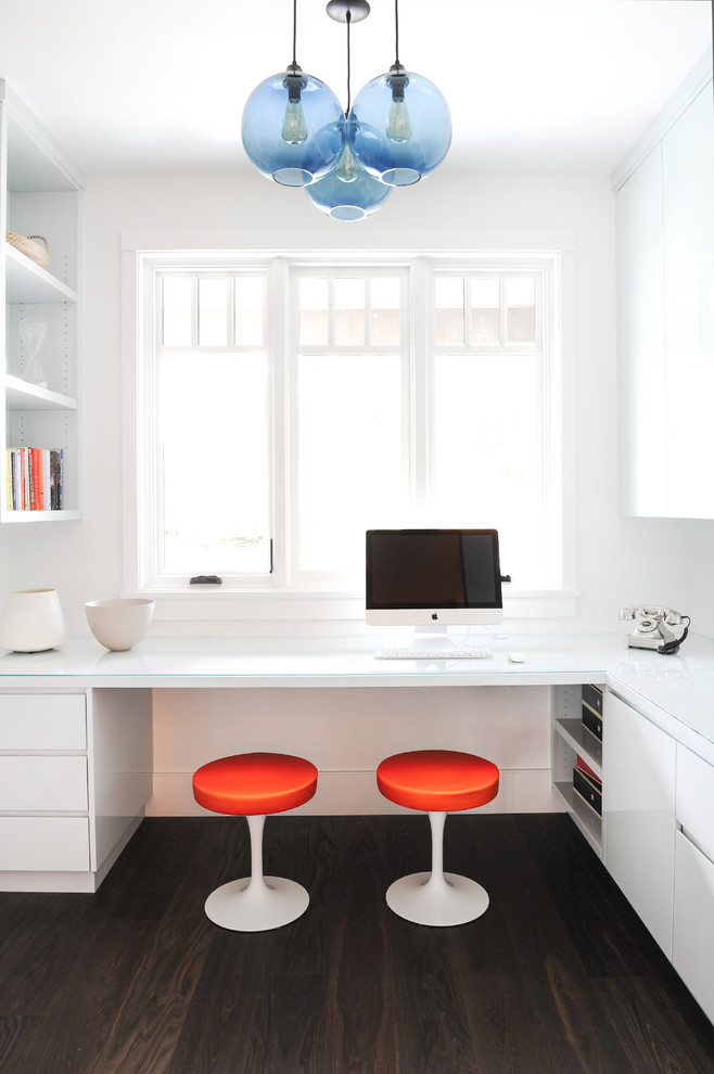 Modernes Arbeitszimmer mit Arbeitsplatz, weißer Wandfarbe, dunklem Holzboden, Einbau-Schreibtisch und braunem Boden in Vancouver