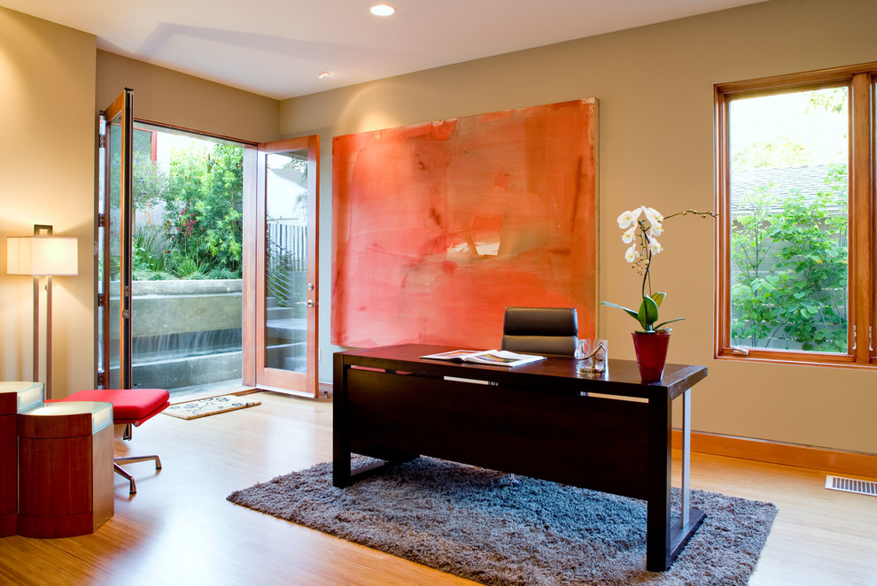 Großes Modernes Arbeitszimmer ohne Kamin mit Arbeitsplatz, brauner Wandfarbe, Bambusparkett und freistehendem Schreibtisch in Los Angeles