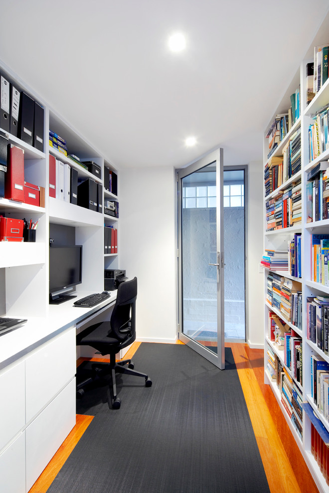 シドニーにある小さなコンテンポラリースタイルのおしゃれな書斎 (白い壁、無垢フローリング、造り付け机、茶色い床) の写真