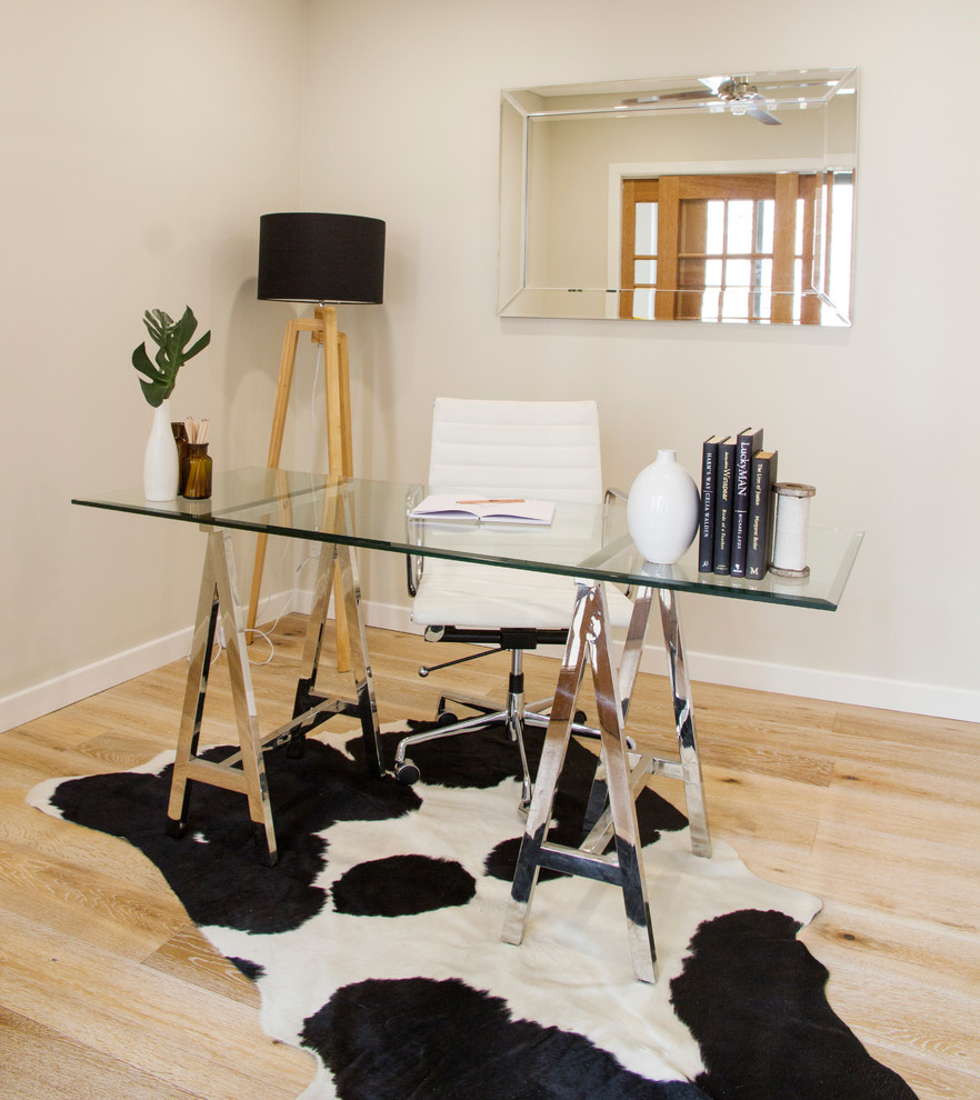 Idee per un piccolo ufficio minimalista con pareti bianche, parquet chiaro, nessun camino e scrivania autoportante