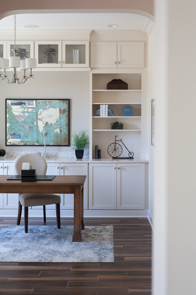 Ejemplo de despacho tradicional renovado de tamaño medio con paredes beige, suelo de baldosas de porcelana y escritorio independiente
