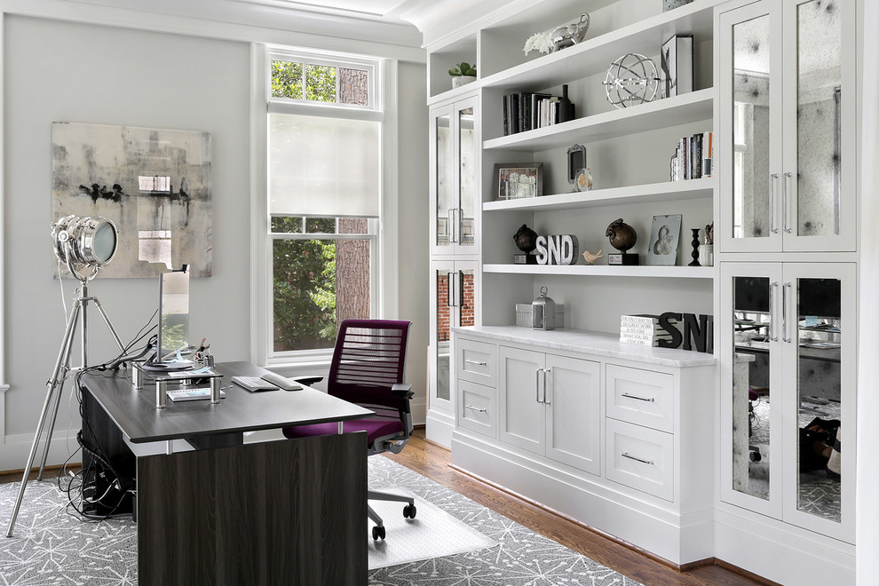 Стильный дизайн: рабочее место в стиле неоклассика (современная классика) с серыми стенами, темным паркетным полом, отдельно стоящим рабочим столом и коричневым полом - последний тренд