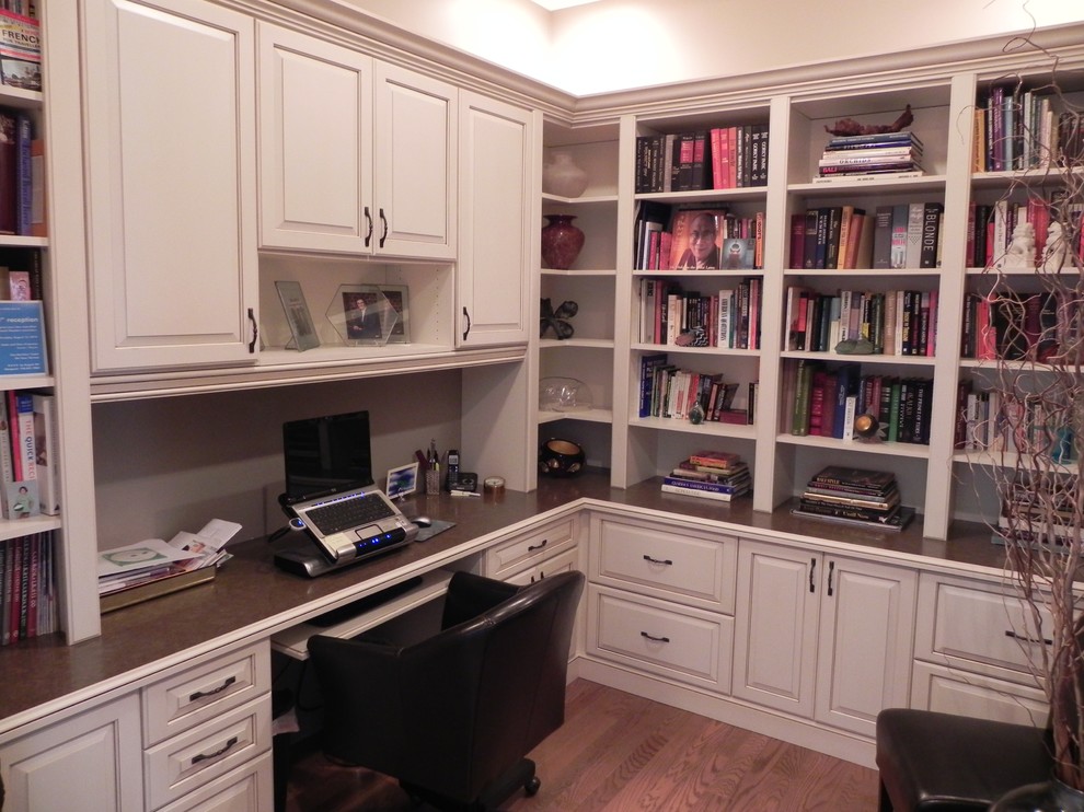 Foto på ett lantligt arbetsrum, med ett bibliotek, mellanmörkt trägolv, ett inbyggt skrivbord och brunt golv