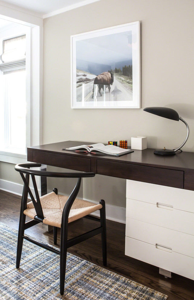 Klassisches Arbeitszimmer mit Arbeitsplatz, grauer Wandfarbe, dunklem Holzboden und freistehendem Schreibtisch in Los Angeles