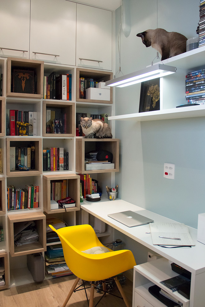 Idéer för små funkis hemmastudior, med blå väggar, ett inbyggt skrivbord och ljust trägolv