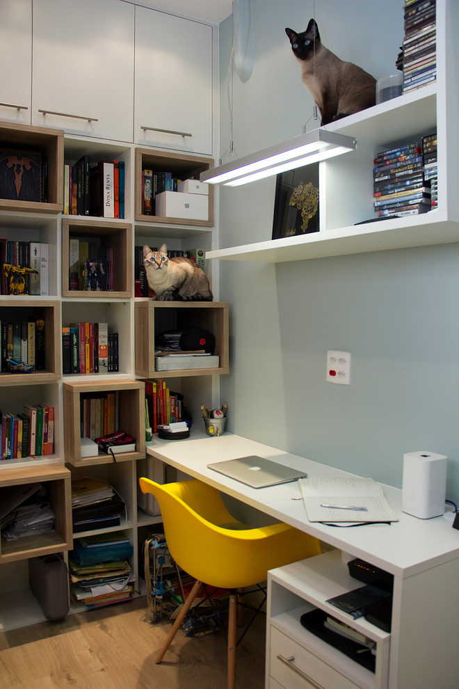 Idéer för ett litet minimalistiskt hemmastudio, med blå väggar, ett inbyggt skrivbord och ljust trägolv