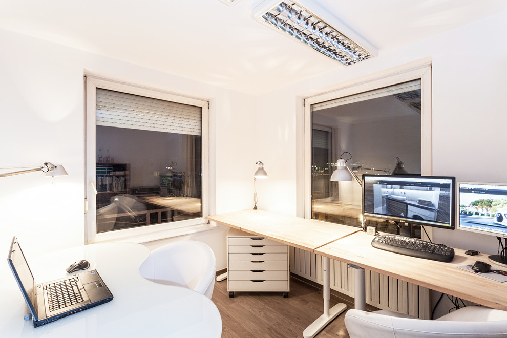 Ejemplo de despacho minimalista pequeño con paredes blancas, suelo de madera oscura, escritorio independiente y suelo marrón