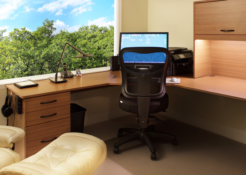 This is an example of a small contemporary home office in New York with beige walls and a built-in desk.
