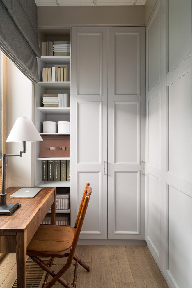 Cette image montre un bureau traditionnel avec un mur gris, parquet clair, un bureau indépendant et un sol beige.